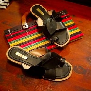 Flat black sandals with a toe and leaf design